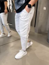 Jean slouchy de color beige, con corte holgado en las piernas y botamangas ligeramente ajustadas o dobladas.