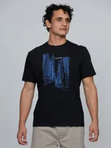 Remera de cuello redondo y manga corta, confeccionada en algodón. Presenta un estampado gráfico lineal en color azul que representa un paisaje urbano con edificios y el logo de la marca.