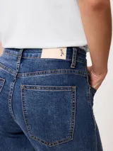 Jean de denim azul con elastano, de tiro medio y corte recto.