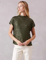 Blusa de cuello alto confeccionada en tejido cubierto de lentejuelas color verde oliva. Presenta mangas cortas con caída natural y forro interno a tono.
