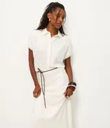 Pollera midi evasê color blanco, confeccionada en viscolino, con cintura alta y cinturón fino negro desmontable.