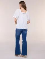 Blusa de corte holgado color marfil, confeccionada en mezcla de modal y algodón, con escote cuadrado y mangas cortas adornadas con detalles de puntilla calada.