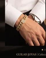 Pulsera tipo cadena cubana de acero con baño de oro, adornada con engarces de micropave de circonias en cada eslabón y en el cierre central.