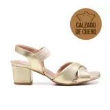 Sandalias de cuero doradas con taco bloque bajo, tiras cruzadas en el empeine y pulsera elástica al tobillo.