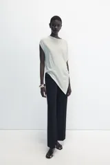 Top de punto color negro, con cuello redondo, manga corta y diseño asimétrico de corte fluido y caída en punta.