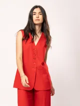 Chaleco color crema de lino con corte sastrero, largo a la cadera, forro interno, botones delanteros, silueta levemente entallada y tajo cruzado en la espalda.