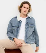 Campera de jean de corte regular, con cuello de solapa forrado en chenille, cierre frontal con botones metálicos y bolsillos frontales en el pecho.