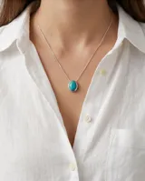 Collar de cadena fina de plata 925 con dije ovalado engarzado que contiene una piedra natural color turquesa.