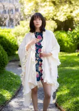 Ruana de textura liviana en color crudo, con diseño amplio y bordes decorados con volados románticos.