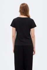 Remera de algodón manga corta, color negro, con cuello en V y estampa frontal en tono plateado con diseño floral y la inscripción 'Bouquet Study No.4'.