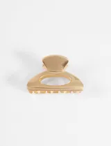 Broche para el pelo tipo clip de diseño ovalado con acabado metálico brillante en tono dorado.