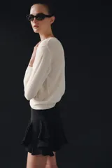 Shorts de tiro medio confeccionado en mezcla de viscosa, con diseño de volantes en el bajo y cierre lateral con cremallera oculta.
