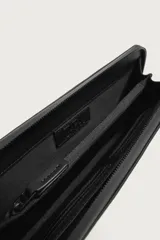 Cartera tipo bandolera de acabado engomado en color negro, con bolsillo frontal con cremallera y compartimento principal con cierre. Asa de hombro ajustable y extraíble.