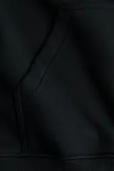 Campera negra de felpa con capucha, cierre frontal completo y bolsillos tipo canguro, de corte holgado y hombros caídos.