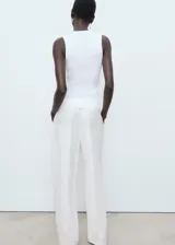 Top de punto canalé color blanco, de diseño entallado con cuello redondo y tirantes anchos sin mangas.