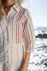 Vestido largo de rayas bordó y blancas, con mangas 3/4, cuello camisero y cierre frontal con botones.