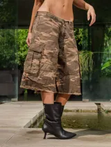 Bermuda cargo de gabardina con lavado, estampado camuflado en tonos marrones y verdes. Presenta bolsillos cargo a los costados y terminación deshilachada en el ruedo.