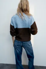 Jersey de punto con cuello redondo y manga larga, de diseño combinado en color celeste en la parte superior y marrón en la inferior y las mangas. Cuenta con un diseño estampado de ositos en el frente.