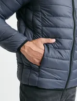 Campera acolchada tipo puffer en color gris, con cierre frontal, cuello alto y puños elásticos.