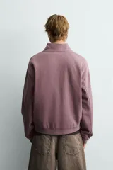 Sudadera de corte boxy fit con cuello subido y cierre frontal de cremallera. Presenta mangas largas, acabado efecto lavado y puños y ruedo en rib.