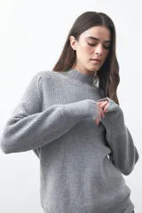 Polera de tejido de punto en color marrón oscuro, con cuello alto y diseño de silueta relajada.