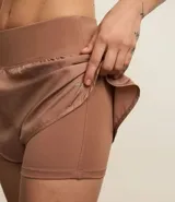 Bermuda deportiva tipo runner, color verde menta, confeccionada en microfibra con cintura elástica. Tiene un corte holgado y bajo redondeado.