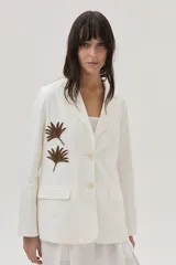 Blazer de lino color blanco con bordados en tonos marrón dorado y plateado, al frente y en la espalda.