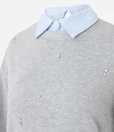 Buzo de algodón gris con cuello redondo, mangas largas con puños ajustados y aplicación de mini beads brillantes distribuidas por toda la prenda.