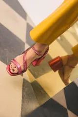 Sandalia de mujer color fucsia metálico con tiras finas adornadas con strass. Posee un taco ancho y bajo, y una tira ajustable en el tobillo.