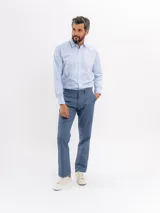 Pantalon chino de corte regular y tiro medio, color azul, con cierre de boton y cremallera, bolsillos laterales y traseros, y terminacion recta.