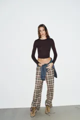 Camiseta de manga larga en color marrón oscuro, confeccionada en tejido de algodón. Presenta un diseño de corte ajustado (slim fit) con cuello redondo.