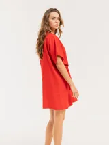 Vestido corto color verde militar, con cuello redondo, mangas cortas y cintura ajustable con cordón.