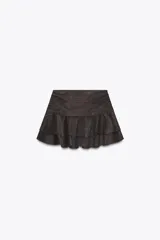 Falda pantalón de tiro medio color marrón oscuro, con detalle de volantes y cierre lateral con cremallera oculta.