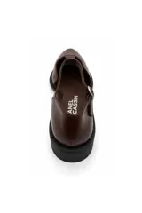 Zapato chatita de Daniel Cassin color negro con acabado brillante, diseño en punta, tira en T y tira ajustable con hebilla al tobillo.