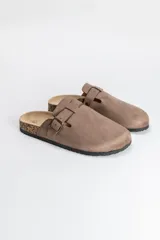 Zueco cerrado color visón con diseño de puntera redondeada, tira ajustable con hebilla metálica y suela con efecto corcho.