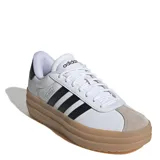 Championes Adidas modelo VL Court Bold, de diseño urbano con plataforma alta. Presentan una base de cuero blanco con las icónicas tres tiras laterales en negro, puntera de gamuza en tono gris claro y suela de goma color caramelo.