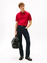 Chomba de corte regular Tommy Hilfiger, color rojo, confeccionada en algodón orgánico con un toque de elastano. Presenta cuello tipo chomba, cartera de dos botones, tejido piqué y logo de la marca bordado en el pecho.