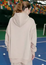 Buzo oversize color nude confeccionado en frisa, con capucha amplia, bolsillo canguro, terminaciones de puño y ruedo con rib, y logo de la marca bordado en el centro delantero.