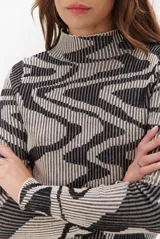 Polera de tejido de punto con diseño vanizado que combina tonos tierra y crema en un patrón abstracto de líneas onduladas. Presenta cuello alto, mangas largas y un ajuste entallado al cuerpo.