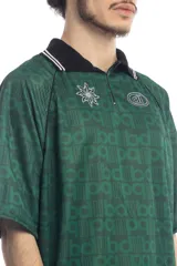 Remera deportiva verde con cuello polo negro con detalles de líneas blancas, mangas cortas con ribete negro y estampado con el logo de la marca en el pecho.