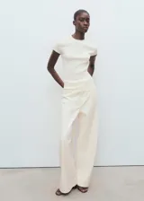 Jersey de punto fino canalé, color blanco, de manga corta y cuello redondo, con diseño recto y ajustado al cuerpo.