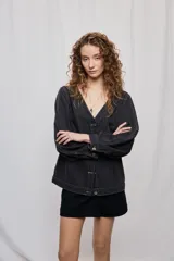 Campera de denim con diseño a rayas verticales y calce recto. Presenta escote en V, cierre frontal con botones metálicos y mangas largas.