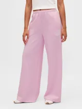 Pantalón deportivo de corte amplio y pierna ancha, color rosado, con cintura elástica y diseño holgado.