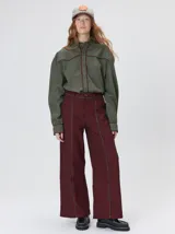 Pantalón sastrero de tiro medio, pierna ancha y corte recto, color bordó con finas rayas verticales y detalles de vivos a contratono en la pretina y el frente.