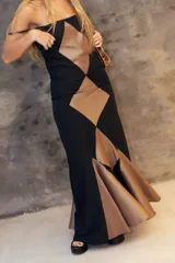 Vestido largo de corte sirena con diseño de rombos en contraste de color negro y marrón. Presenta breteles finos, escote recto y falda con vuelo en el ruedo que genera movimiento.
