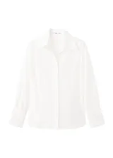 Camisa blanca de manga larga con detalles bordados calados en el frente y puños anchos.