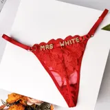 Tanga colaless de encaje rojo con tiras regulables y apliques de letras de strass en la parte delantera.