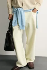 Jeans straight fit color beige claro, con tiro medio, pernera recta de cinco bolsillos y cierre frontal con cremallera y botón.