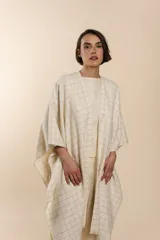 Ruana de lana fina color crudo con terminación envivada.