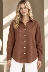 Camisa de lino color mostaza, de corte clásico con cuello camisero, manga larga y cierre frontal abotonado.